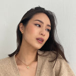 girl wearing christian dior necklace with demi fine gold vermeil crescent huggie earrings