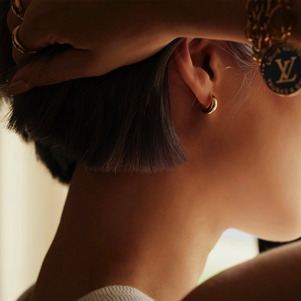 girl wearing gold jewelry and the louis vuitton repurposed designer necklace as a bracelet around the wrist